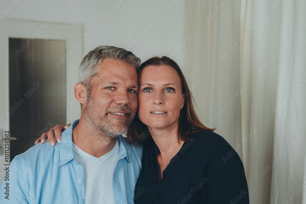 A happy couple is having fun at home while sitting on the floor. A happy couple is having fun at home while sitting on the floor.