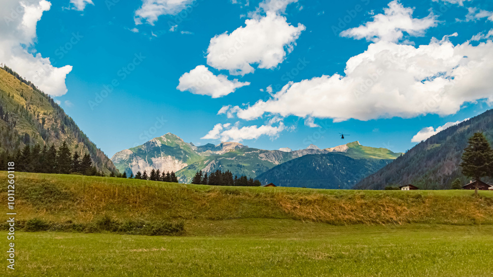 Alpine summer view with a helicopter in flight at Kalser Glocknerstrasse High Alpine Road, Kals am Großglockner, Lienz, Eastern Tyrol, Austria Alpine summer view with a helicopter in flight at Kalser Glocknerstrasse High Alpine Road, Kals am Großglockner, Lienz, Eastern Tyrol, Austria