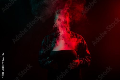 Photo of sorcerer conjurer hold cauldron make conducting ritual halloween night isolated on dark misty mysterious background