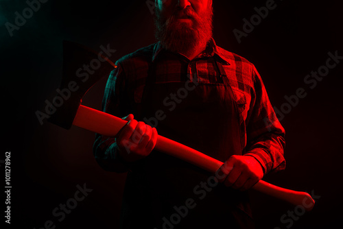 Photo of halloween male character furious man killer maniac hold sharp ax isolated on dark misty mysterious background