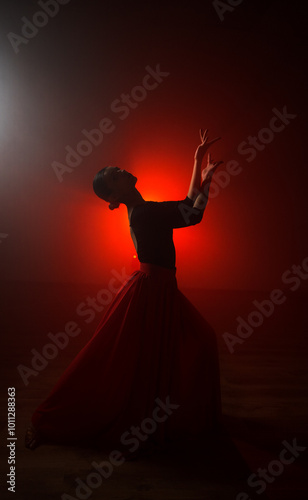 Silhouette of a woman in a red skirt dancing Latin in smoke in neon light. Dance concept. Bachata, Latina