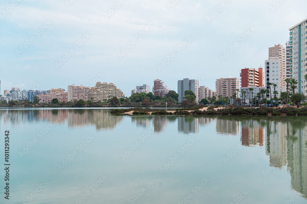Cityscape with modern buildings reflected in calm water Cityscape with modern buildings reflected in calm water