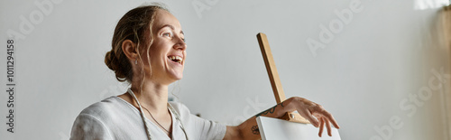 Wallpaper Mural A joyful woman expresses happiness while painting in a well-lit studio. Torontodigital.ca