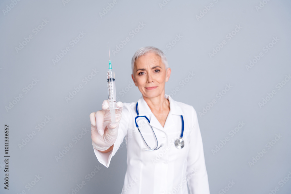 Photo of woman qualified specialist wear white robe injection vaccine injection isolated on grey color background Photo of woman qualified specialist wear white robe injection vaccine injection isolated on grey color background