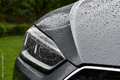 A close-up of a car with water droplets. Headlight