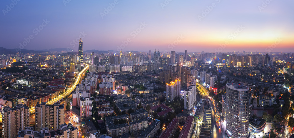 Obraz premium Stunning Cityscape Panorama at Sunset, Illuminated Skyline with Urban Architecture