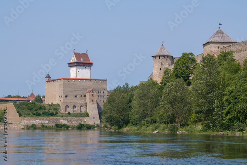 The ancient Herman Castle and Ivangorod Fortress on the Narva River on a sunny July day. The border of Russia and Estonia photo