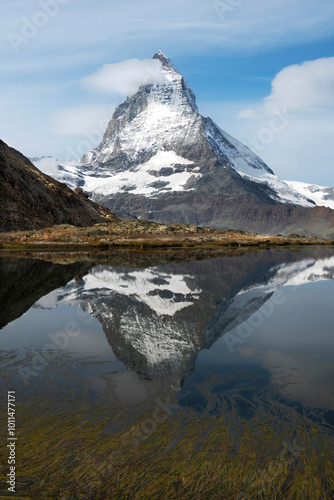 The Magnificent Matterhorn features its iconic, pyramid-like peak soaring into a crisp, clear sky. 
