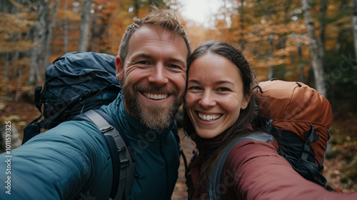 A happy couple taking a selfie during a scenic forest hike