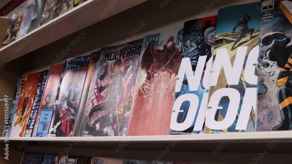 Obraz premium CARDIFF, MID GLAMORGAN, WALES UK - OCTOBER 3, 2024: COMIC BOOKS ON SHELVES DISPLAY PAPERBACKS