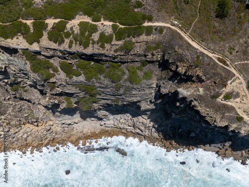 A bird s eye view of a rocky coastline with crashing waves photo