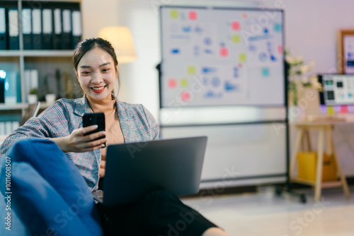 Young businesswoman is working from home, using her laptop and smartphone to stay connected with colleagues and clients