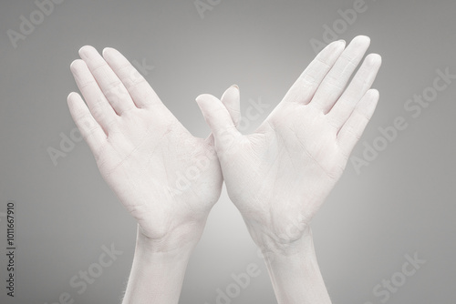 Two hands elegantly raised against a gentle gray backdrop symbolize patriotism and remembrance on memorial day.