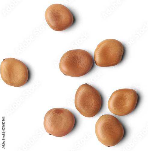 scattered pebble or velvet tamarind seeds isolated white background, small dark brown shiny smooth seeds with hard shell native to sri lanka used to germinate, close-up macro view