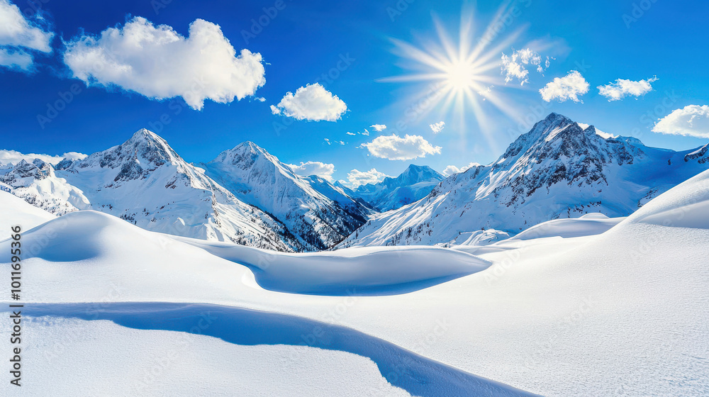 Obraz premium Majestic snowy mountain landscape under a bright sun and vibrant blue sky with soft clouds drifting above