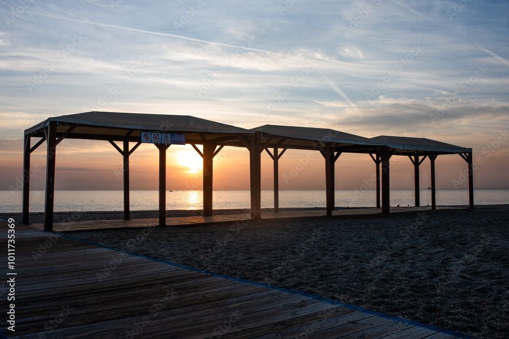 Fototapeta premium Wooden gazebos by the sea at sunset.