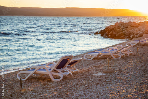 Fototapeta Naklejka Na Ścianę i Meble -  Sun setting at the pebble beach in Brela, Croatia