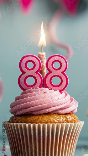Birthday cupcake with burning lit candle with number 88. Number eighty-eight for eighty-eight years or eighty-eighth anniversary. photo
