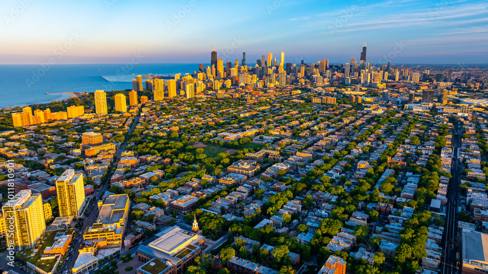 Fototapeta premium Green uptown and high-rise downtown of Chicago, Illinois in the rays of setting sun. Amazing blue waterscape of Lake Michigan at backdrop.