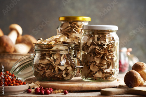 Dried and fresh wild king bolete or porcini mushrooms in glass jars