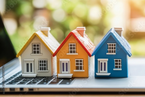 House models standing on a laptop. Concept of selling and buying real estate