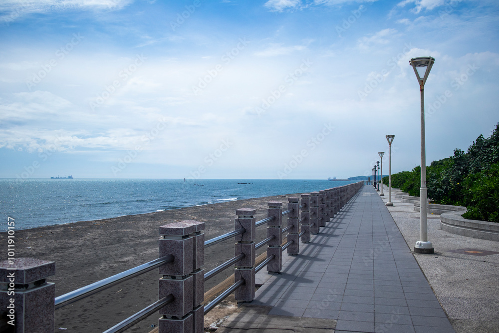 A Fresh Coastal Pathway, Where the Blue Sky and Street Lights Reflect Each Other, Depicting a Scene of Harmony Between Humanity and Nature A Fresh Coastal Pathway, Where the Blue Sky and Street Lights Reflect Each Other, Depicting a Scene of Harmony Between Humanity and Nature