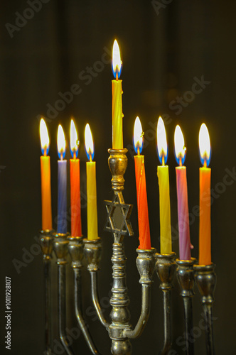 Menorah with multicolored candles on a dark background