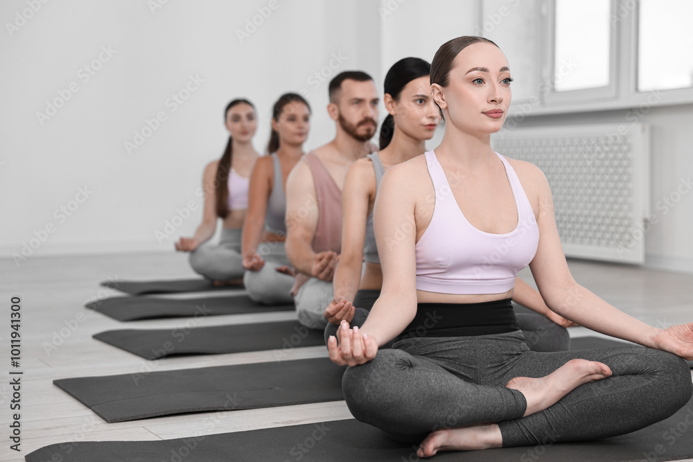 Group of people meditating on mats in yoga class Group of people meditating on mats in yoga class
