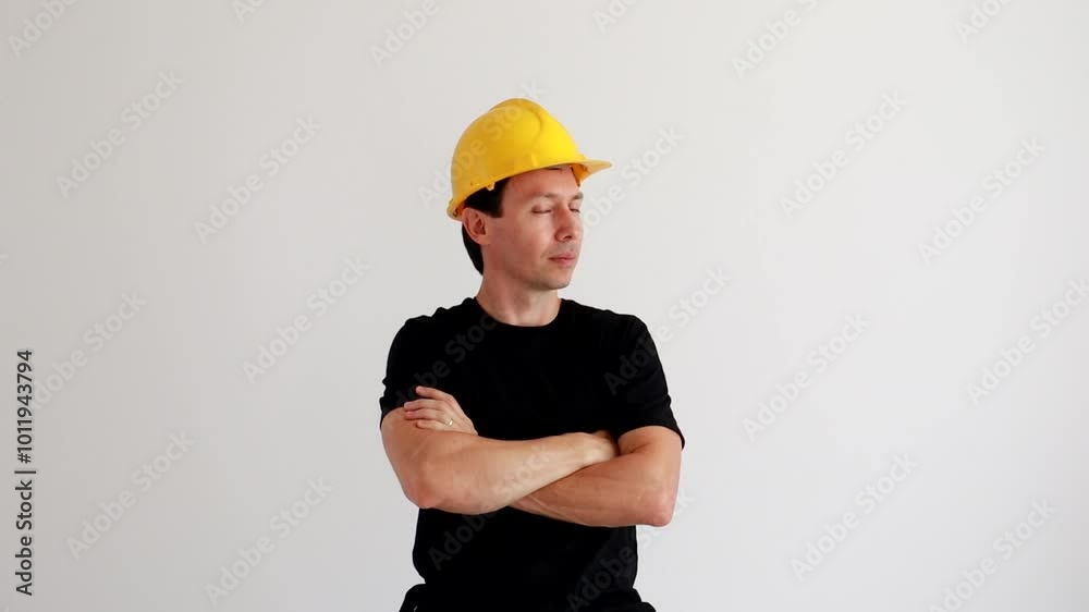 engenheiro usando capacete amarelo de braços cruzados 