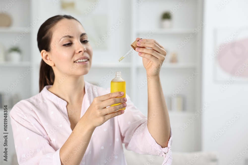 Young woman taking CBD tincture indoors, space for text Young woman taking CBD tincture indoors, space for text