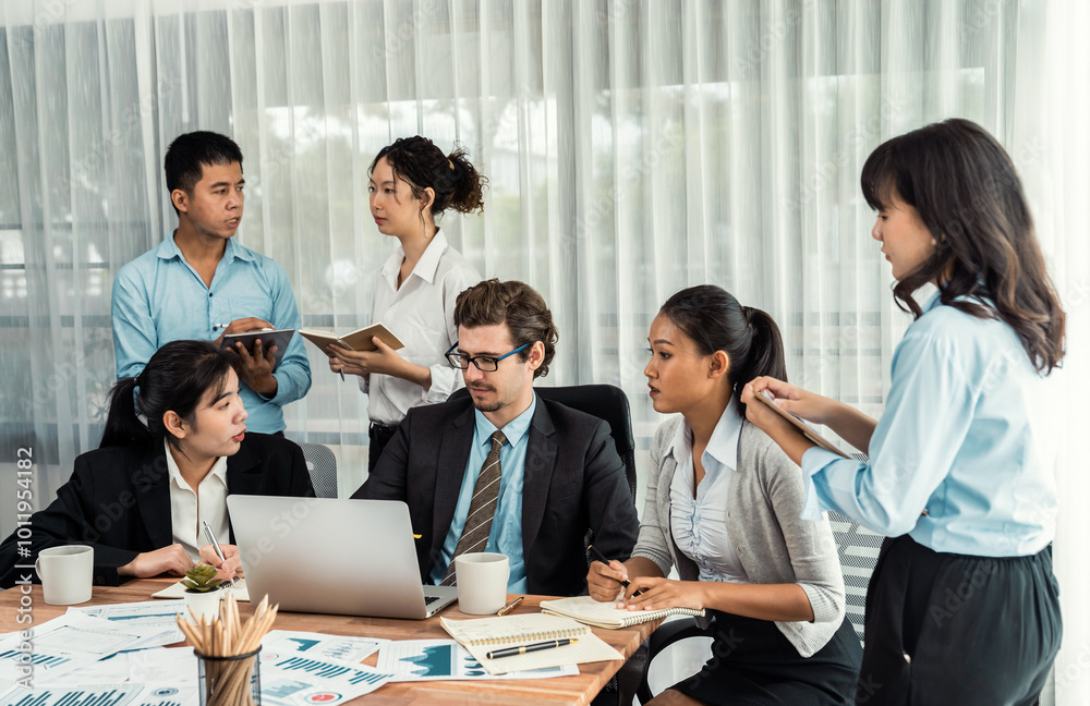 Diverse of business people from various ethnic group working in modern office environment. Productive and multi ethnic office workers engage in discussion for strategic business marketing. Meticulous