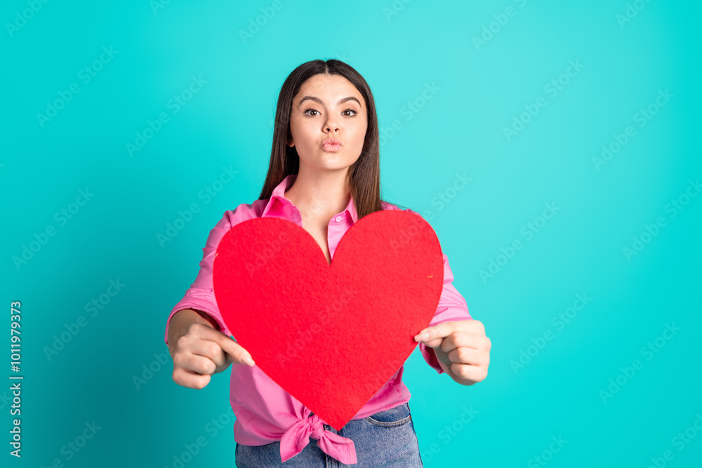 Photo portrait of lovely teen lady hold big heart postcard dressed stylish pink garment isolated on cyan color background Photo portrait of lovely teen lady hold big heart postcard dressed stylish pink garment isolated on cyan color background