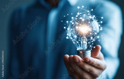 Businessman holding a glowing light bulb with interconnected digital network, symbolizing innovation and creativity in modern technology and business solutions.