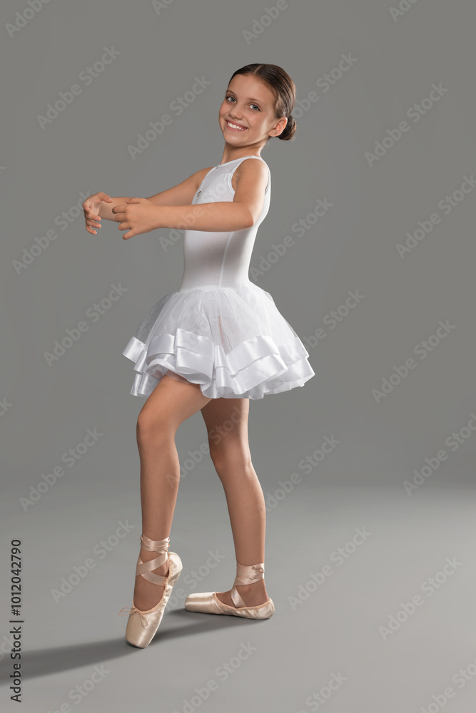 Naklejka premium Cute little ballerina dancing on grey background