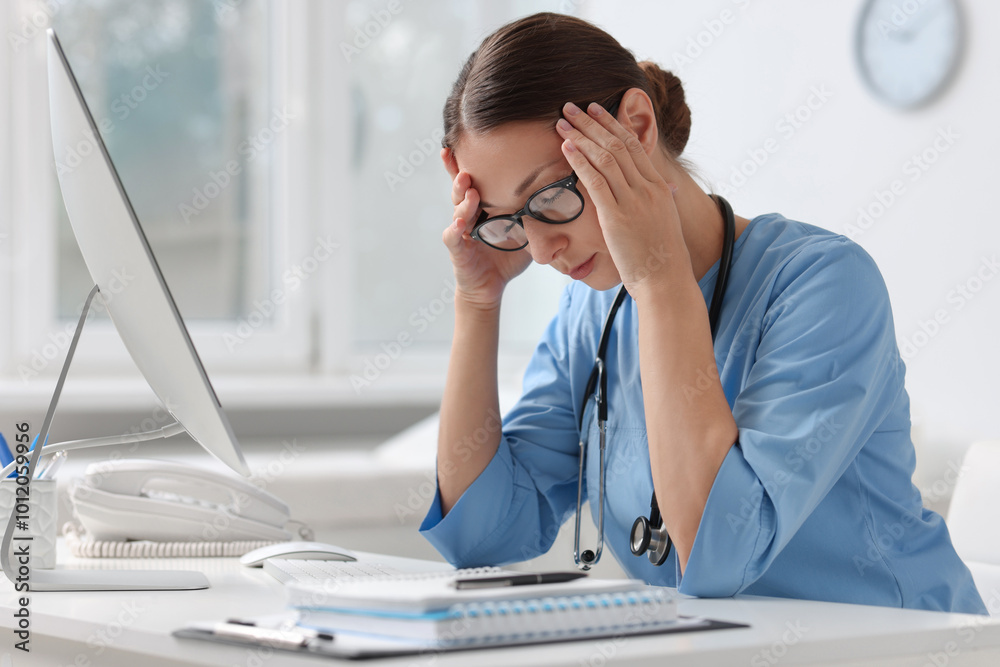 Tired nurse at white table in clinic Tired nurse at white table in clinic
