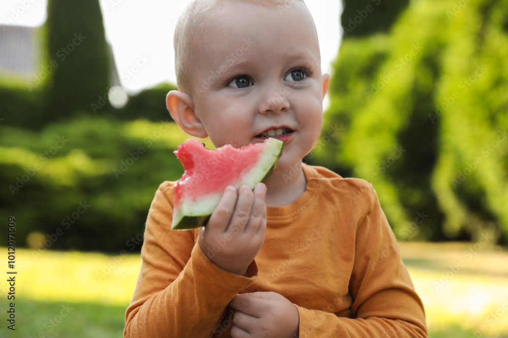 Cute little baby eating juicy watermelon outdoors Cute little baby eating juicy watermelon outdoors