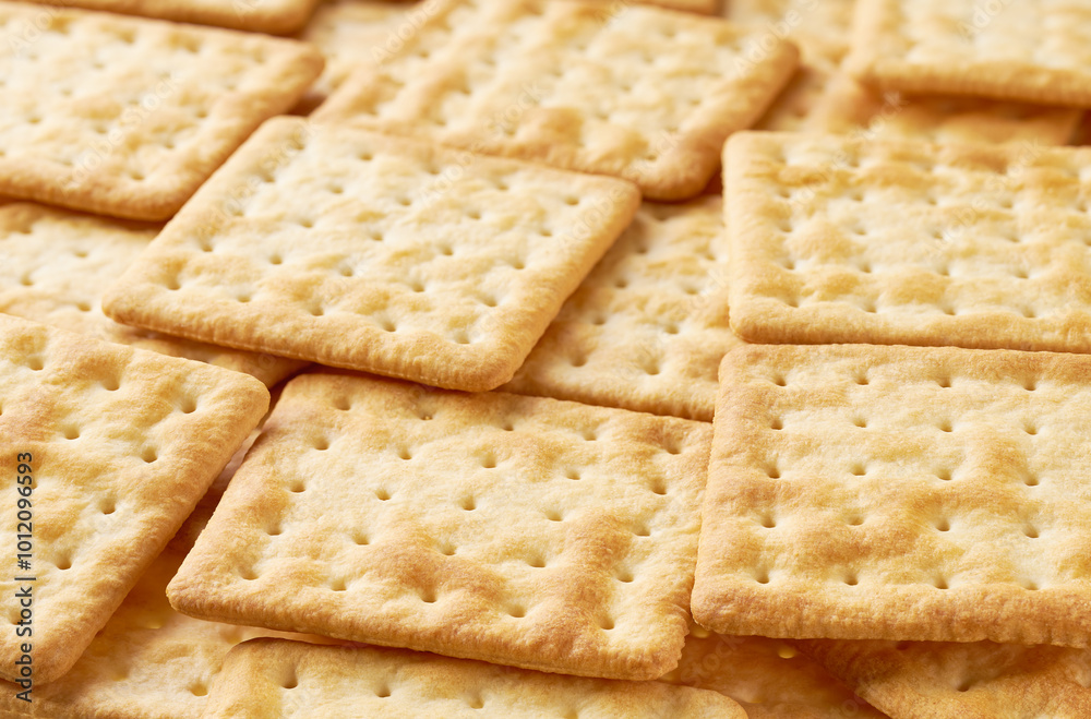 Square water crackers  placed throughout the screen selective focus. Food background.