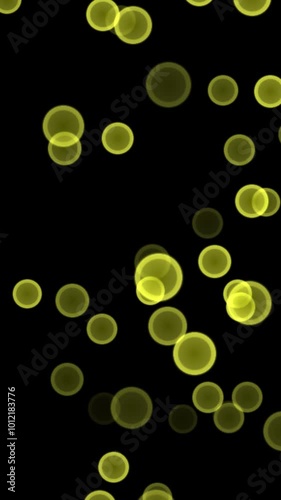 vertical animation of luminous yellow round shapes floating against a black background for festive designs
