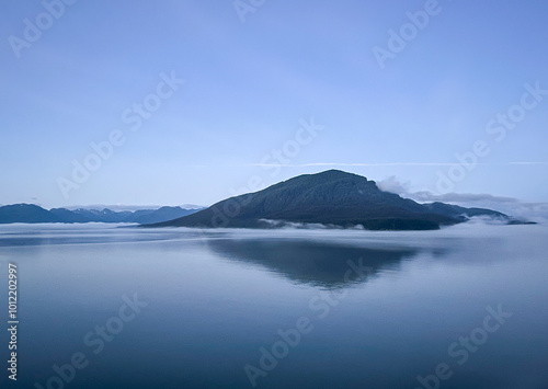 Mountain Range On The Water With Low Laying Fog