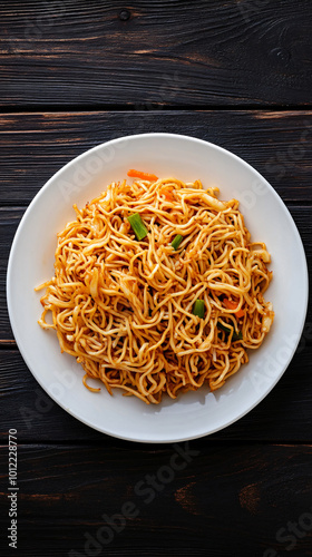 Steaming stir-fried noodles with fresh veggies on a white plate, perfect for lunch or dinner. Authentic asian dining experience on a wooden table