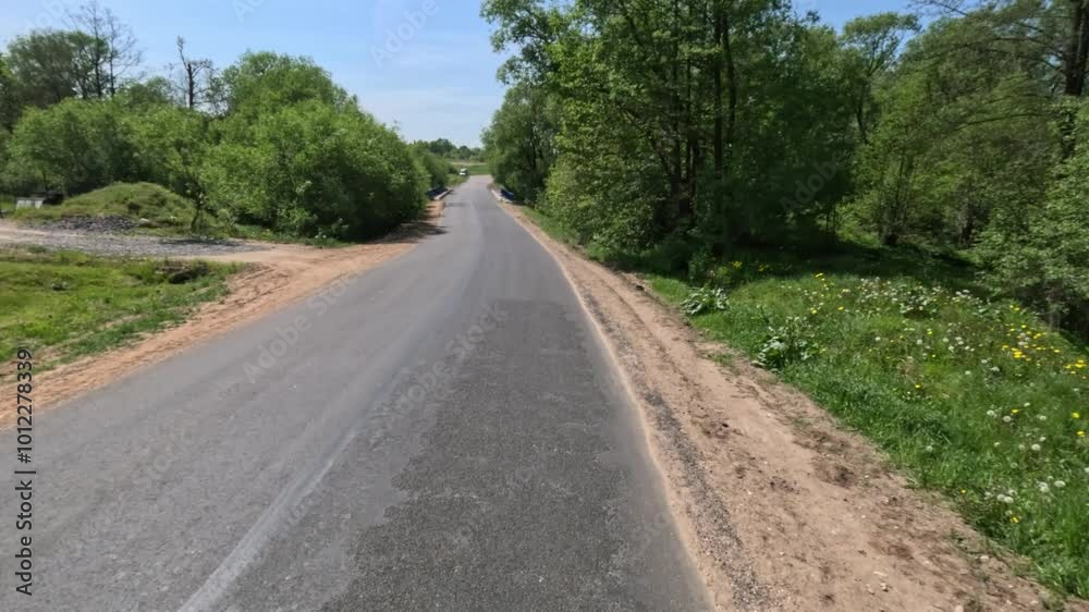 View back to the road on a summer day from a red car. Highways and roadsides move away from the car. View back to the road on a summer day from a red car. Highways and roadsides move away from the car.