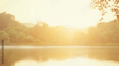 A soft, blurred sunrise over a calm lake with a clear sky for text