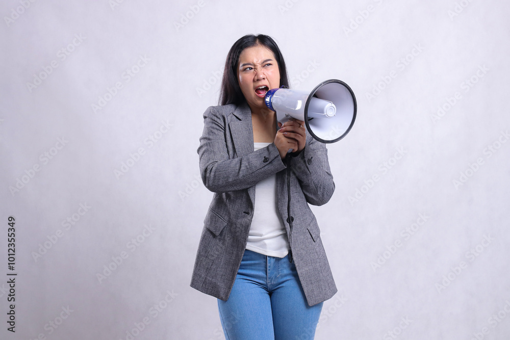 beautiful female screaming formal angry candid both hands holding loudspeaker megaphone forward wearing gray suit isolated on white background. fashion, lifestyle, advertising, sale, company concept beautiful female screaming formal angry candid both hands holding loudspeaker megaphone forward wearing gray suit isolated on white background. fashion, lifestyle, advertising, sale, company concept