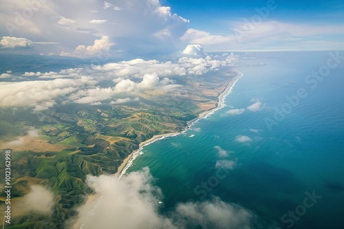 Aerial view of coastal landscape with lush green hills and turquoise ocean