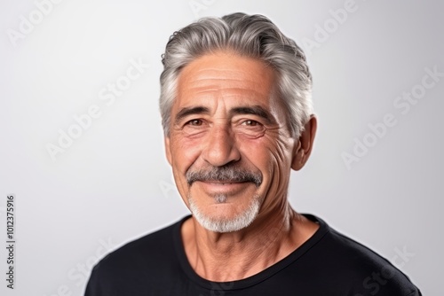 Portrait of a handsome senior man with grey hair on grey background