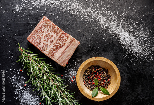 Fototapeta Naklejka Na Ścianę i Meble -  An elegant and visually appealing display of marbled meat, various herbs, and spices for exquisite culinary creations