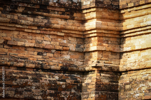 Close-up of old, weathered bricks forming a detailed corner of a temple, showcasing traditional construction with natural aging, subtle cracks, and mossy textures