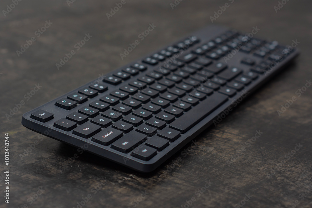 Black wireless computer keyboard on a dark concrete table. Black wireless computer keyboard on a dark concrete table.