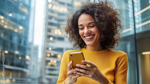 With skyscrapers in the background, a young woman uses a banking app on her smartphone while smiling.