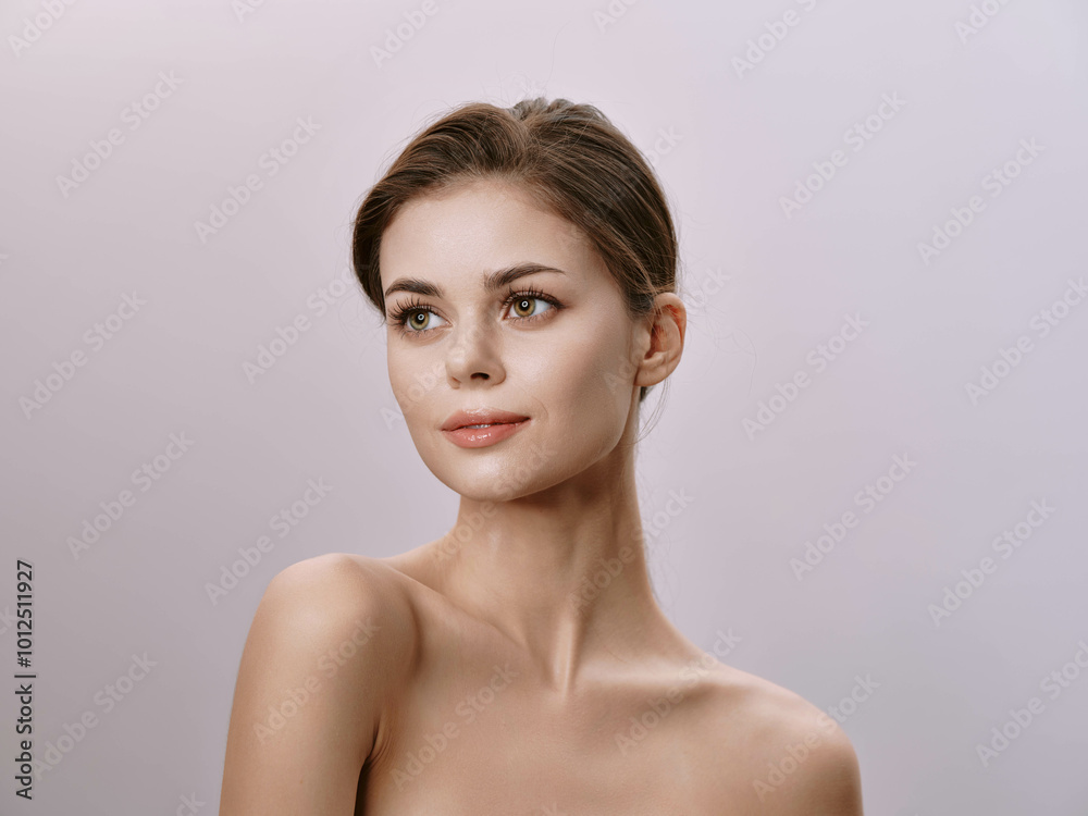 Beautiful young woman with natural appearance looking to the side on a gray background Beautiful young woman with natural appearance looking to the side on a gray background